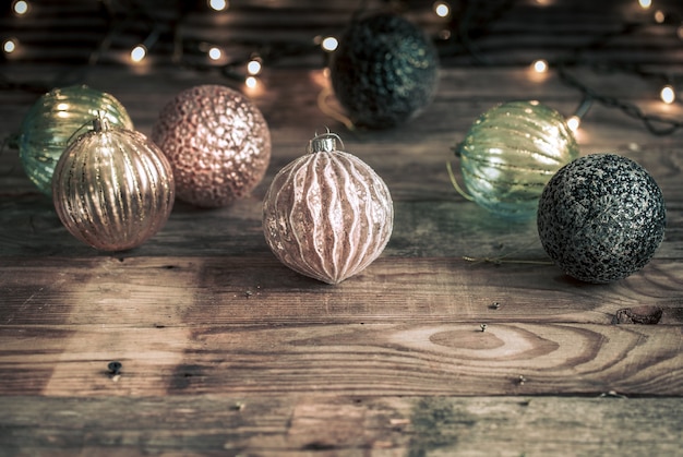 Sfondo festivo di natale o capodanno, giocattoli vintage sull'albero di natale su uno sfondo di legno con una ghirlanda con luci