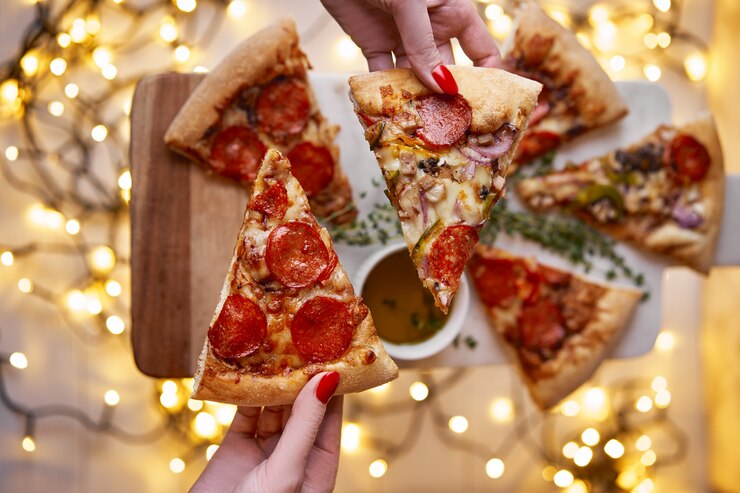 Christmas and New Year festive. Woman's hand takes slice of Italian pizza pepperoni.