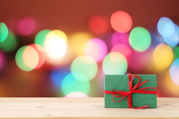 Christmas, new year gift box on wood table over blur festive bokeh light background