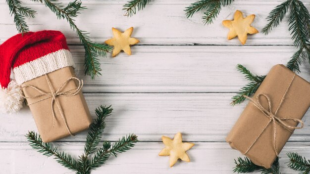 Regali di natale e capodanno sul tavolo con rami di albero di natale e biscotti con dolci