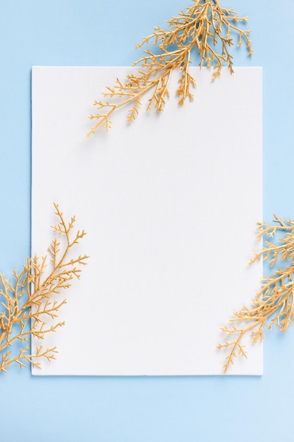 Christmas and new year goal planning mock up with note and golden branch on blue background and backdrop flat lay copy space top view vertical