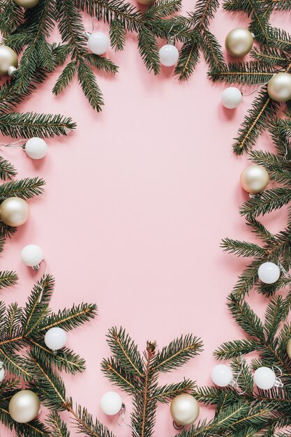 クリスマス年末年始の構成。空白のコピースペース、モミの針の枝、ピンクのクリスマスつまらないものでフレームをモックアップ