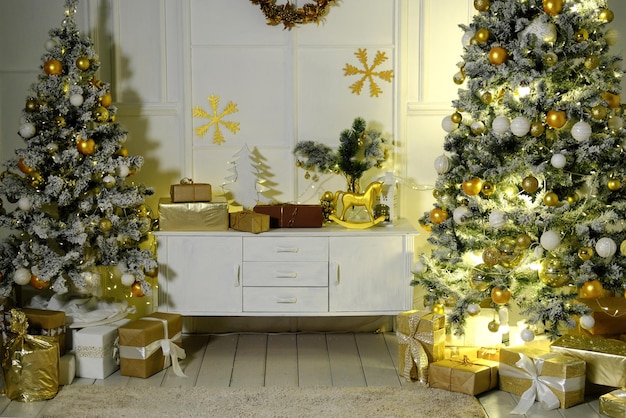 Christmas and New Year interior room with a high Christmas tree decorated with golden balls and a garland
