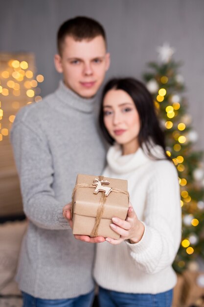 クリスマス新年と愛の概念の若いカップルの愛のギフトボックスを保持します。