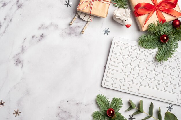 Christmas and new year office work space with keyboard gift box\
and christmas tree flatlay top view