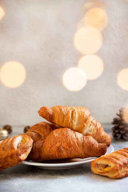 Dolci di natale o capodanno, cornetti al cioccolato e mela. atmosfera natalizia. concetto di vacanze invernali. sfondo chiaro. messa a fuoco selettiva