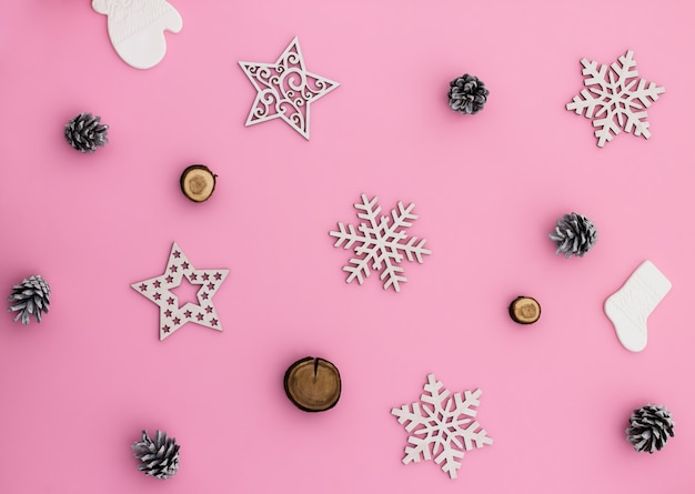 Christmas and New Year. Pink flat lay pattern with snowflakes, Christmas toys and cones.