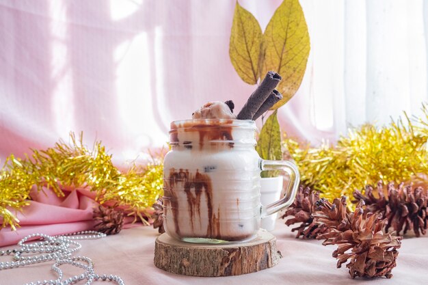 Foto concetto minimalista di natale e capodanno. la composizione mostra il prodotto. bevanda al latte ghiacciata al cioccolato su legno con decorazioni di natale e capodanno