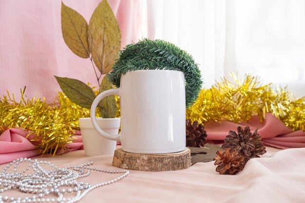 クリスマスと新年のミニマリストのコンセプト。製品マグをフィーチャーした構成。クリスマスと新年の装飾が施された木のマグカップ