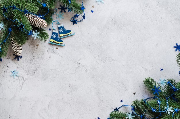 Natale di capodanno con rami di abete e palline blu su un cemento grigio.