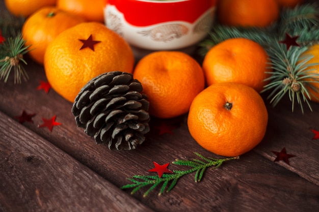 Christmas new year with tangerines, tea and sweets on the table. winter still. selective focus.