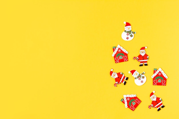 Christmas and New Year wood decoration on yellow background Xmas red toys with copy space