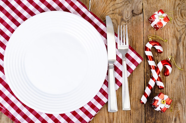 Christmas and new years concept. white plate, red tablecloth.