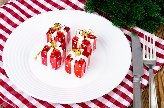 Christmas and New Years concept. White plate, red tablecloth.