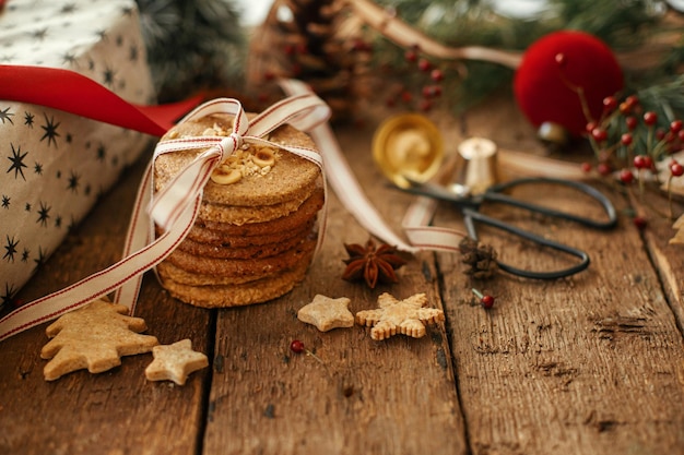 クリスマス オートミール クッキーは素朴なテーブルにギフトの装飾を包んだ雰囲気のメリー クリスマス