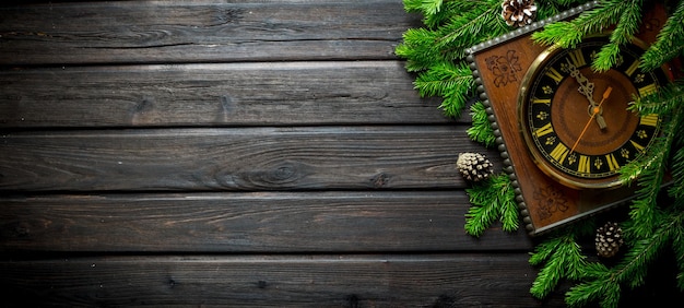 Christmas old clock with cones and fir branches