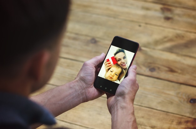 Рождественские онлайн-поздравления мужские руки держат смартфон и болтают с семьей