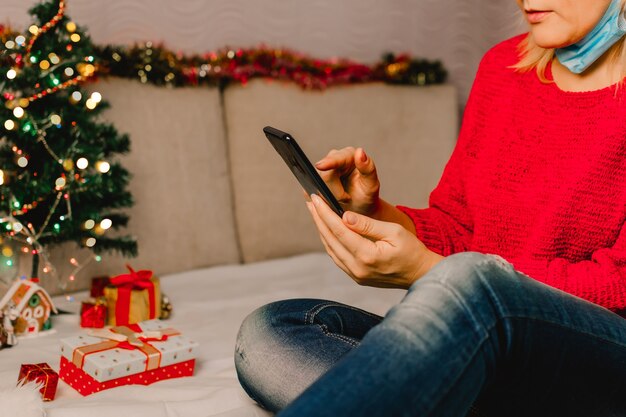 Christmas online shopping. Female buyer makes order on mobile phone