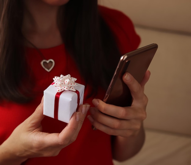 Christmas online shopping A woman is buying gifts preparing for Christmas a gift box in her hands Sales during the winter holidays