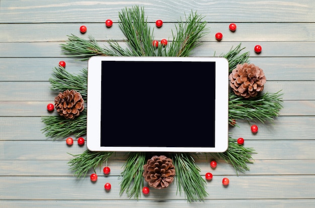 Рождество или новогодний фон на деревянных фоне. планшет с пустым экраном для приветствия. плоская планировка, вид сверху, копия пространства