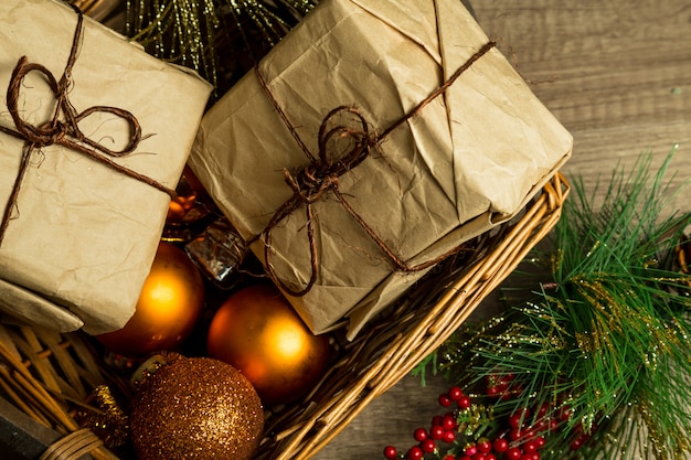 Christmas oraments and gift boxes on a wicker basket