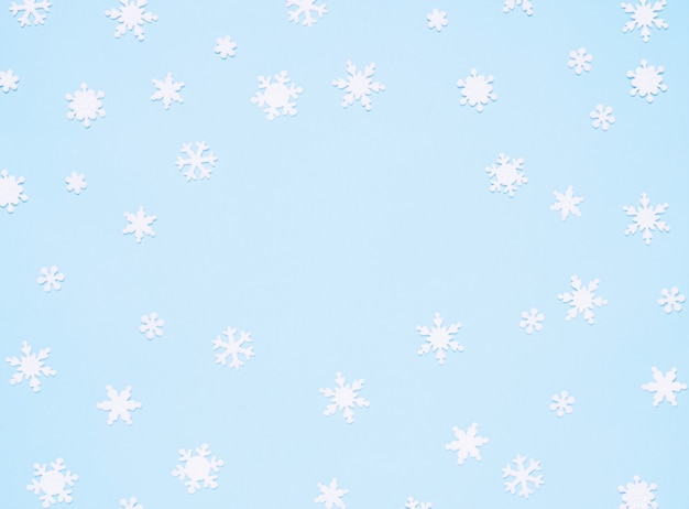 青い背景に雪片とクリスマスの飾り。