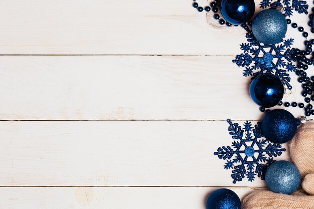 Christmas ornaments decorations background. glass balls blue stars and beads on wooden white table
