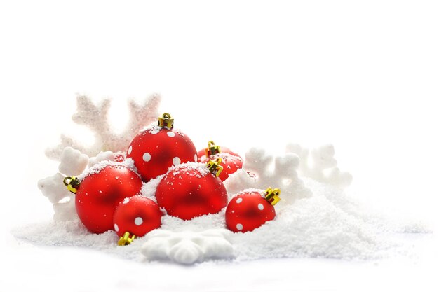 Christmas ornaments on snow isolated on white background