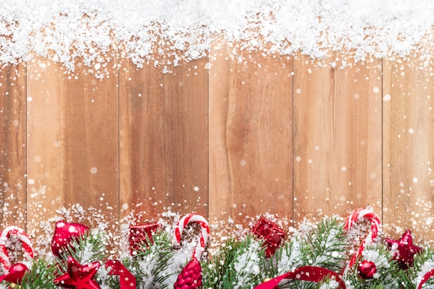 Christmas ornaments with snow decoreted on wood background