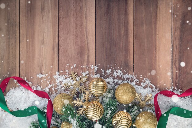 Christmas ornaments with snow on wood background