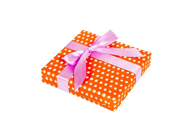 Christmas or other holiday handmade present in orange paper with purple ribbon. Isolated on white background, top view. thanksgiving Gift box concept.