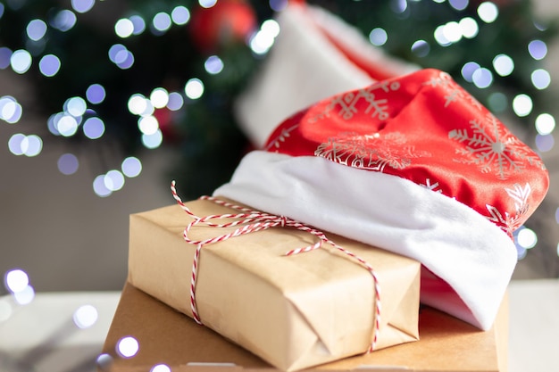 Foto pacco di natale regalo di capodanno o regalo con sfondo bokeh scintillante e albero di natale