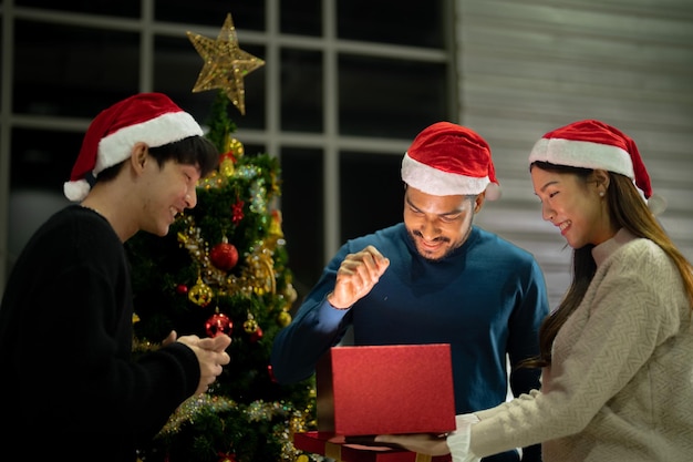 Foto festa di natale per celebrare il nuovo anno amici che si divertono insieme a casa albero di natale