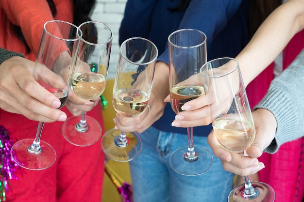 Tempo di festa di natale. giovani asiatici brindando con flauti champagne. amici che si congratulano con il nuovo anno.