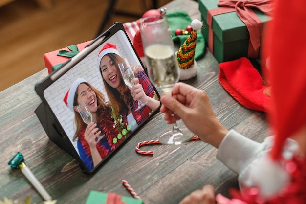 Christmas party video call with friends and toasting champagne party together at home