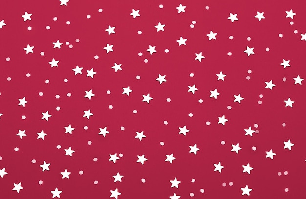 Christmas pattern made of silver stars. New 2023 trending PANTONE 18-1750 Viva Magenta colour