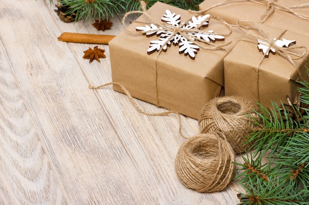 Рождественский образец со снежинкой, сосновыми шишками, еловыми ветками, рождественским подарком.