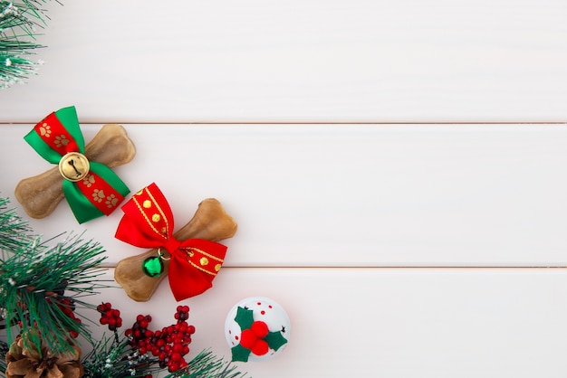 Christmas for pets. Dogs bones wrapping in Christmas bows, jingle bell on white wooden.