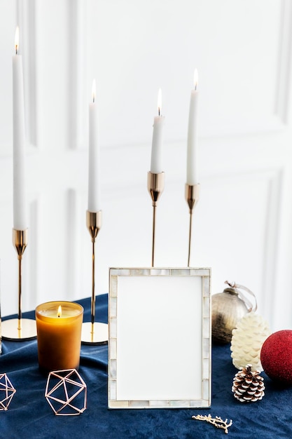 Christmas photo frame on a table with taper candles