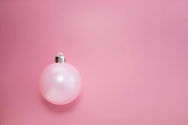 Christmas pink ball with a shadow on a pink background