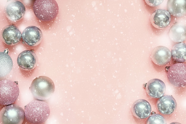 Christmas pink and silver baubles as frame on pastel pink background