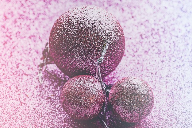 Christmas pink toy balls on a Christmas tree on pink glitter. New Year's ornament.