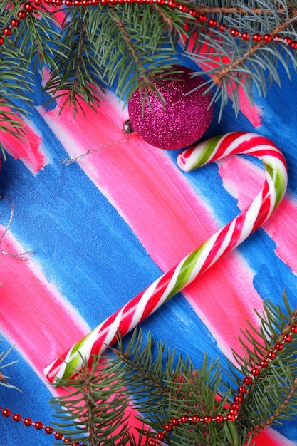 Christmas pink toys candy cane christmas tree branches on a bluepink background christmas concept closeup