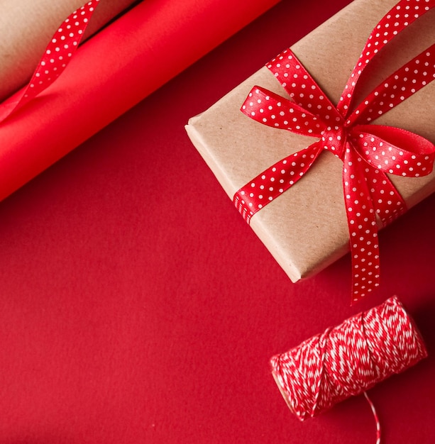 Christmas preparation boxing day and holidays gift giving xmas\
craft paper and ribbons for gifts boxes on red background as\
wrapping tools and decorations diy presents as holiday flat\
lay