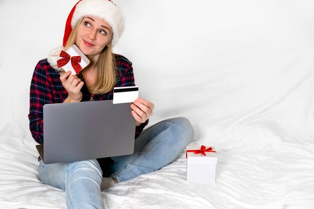 Christmas present. Mischievously smiling woman with gift box