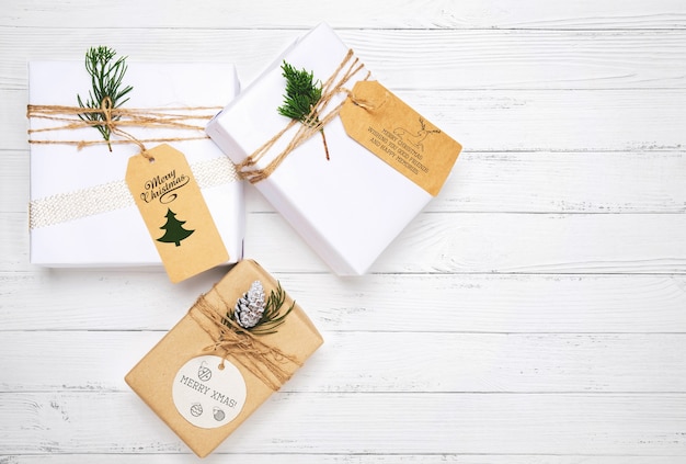 christmas present and pine leaves decoration on white wood table