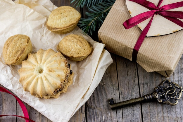 Christmas present with cookies and key on wooden table