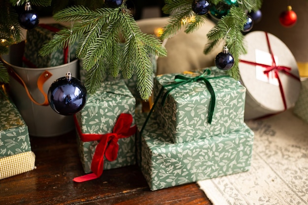 Photo christmas presents under the christmas tree with green blue and red christmas balls at home