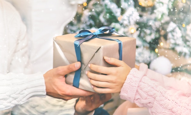 Christmas presents in the hands of a man and a woman. Holiday. Selective focus.