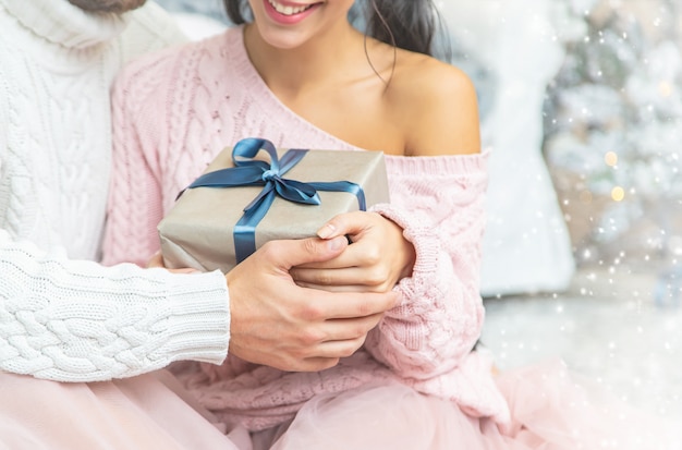 Regali di natale nelle mani di un uomo e una donna, messa a fuoco selettiva.